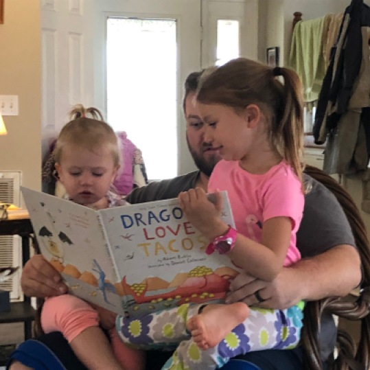 uncle reading with nieces